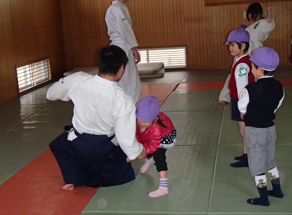 大学生と合気道の組み手をする園児