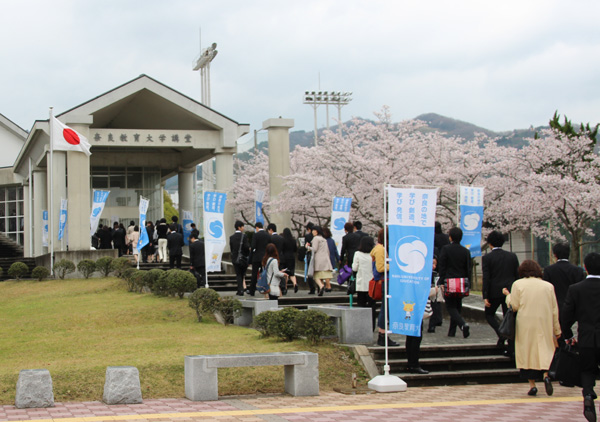 満開の桜の下講堂へ