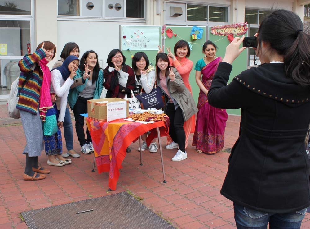 民族衣装を着た留学生と記念撮影をする日本人学生ら
